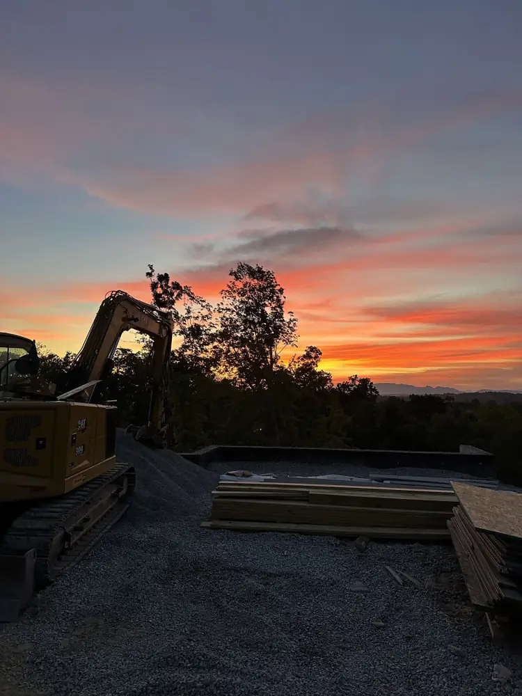 Excavator on a job site at sunset