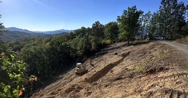 Cleared hillside with an excavator and mountain views in East Tennessee