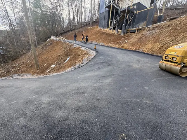 Asphalt driveway curve with roller on site
