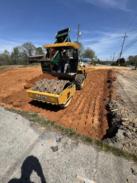 Compactor rolling a prepared pad