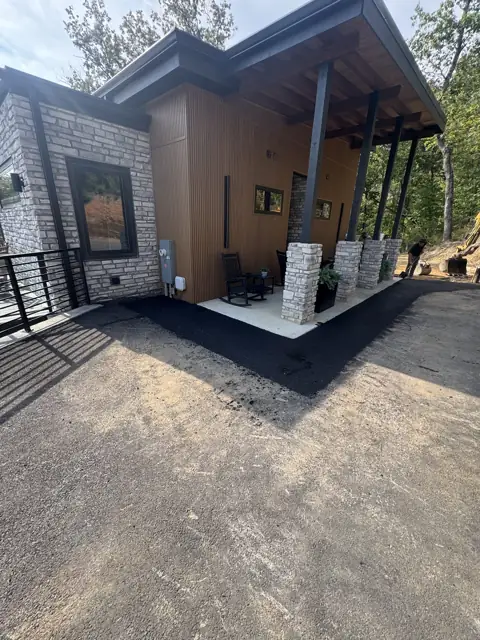 Asphalt work beside a stone-faced home