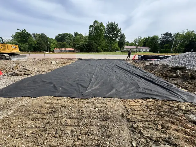 Fabric laid over a graded pad before stone